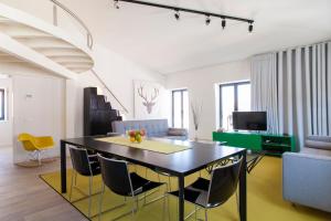 リスボンにあるJOIVY Lux and Spacious 1BR home with huge terrace, 5mins to Academy of Sciencesのダイニングルーム、リビングルーム(テーブル、椅子付)