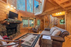 a living room with a fireplace in a log cabin at Bear Paw Trail in Sevierville