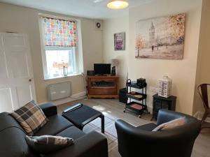 a living room with a couch and chairs and a tv at Cottage on the Solway Coast in Port Carlisle