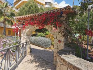 an archway with red flowers in a garden at Apartamento Tosca Mar in Moraira