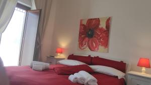a bedroom with a red bed and a window at Tra le Mura in Polignano a Mare