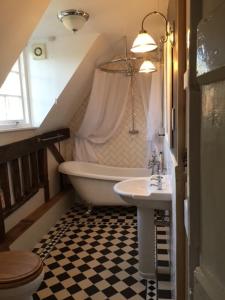 ein Badezimmer mit einer Badewanne und einem Waschbecken in der Unterkunft Mulleys Cottage (Bed and Breakfast) in Westleton