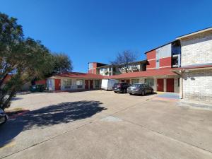a parking lot in front of a building with cars at River Inn Motel in San Antonio
