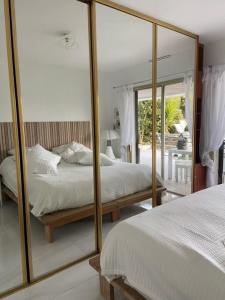 カシにあるLA MAISON DE DOMS avec JACUZZIのベッドルーム1室(ベッド2台、鏡付)
