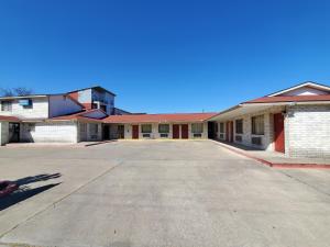 un aparcamiento vacío frente a un edificio en River Inn Motel, en San Antonio