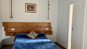 um quarto com uma cama azul e uma cabeceira em madeira em Estudio Pajar rural con bonito jardín - Los Gayoles Rural em Castropol