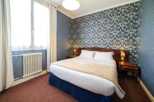 Un dormitorio con una cama grande y una ventana en The Originals Boutique, Hôtel Normandie, Auxerre, en Auxerre