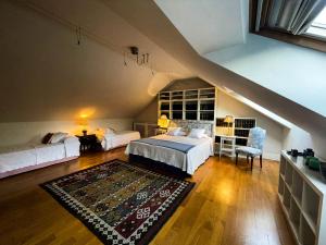 a attic bedroom with two beds and a staircase at La Casa de Somio in Gijón +35 photos