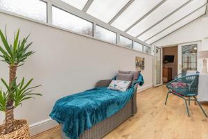 a conservatory with a couch in a room with windows at Postman's Cottage in Bridlington