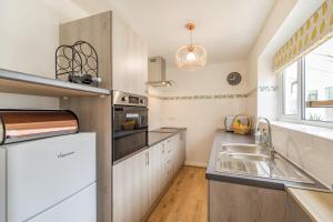 a kitchen with a sink and a stove top oven at Postman's Cottage in Bridlington