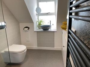 a bathroom with a toilet and a window at No 4 old post office row Isle of Skye - Book Now! in Eyre