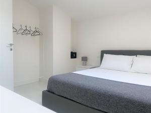 a white bedroom with a bed and a chandelier at Residenza DaMa in Lucera