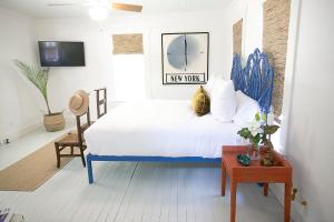 a bedroom with a blue and white bed and a chair at The Frenchie in Round Top