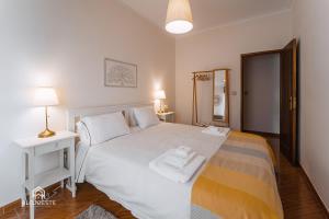 um quarto com uma cama branca, uma mesa e um espelho em Maria Sabe Tudo - Santa Cruz em Santa Cruz