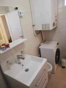 a bathroom with a sink and a washing machine at Sunny Heaven Apartments in Izola