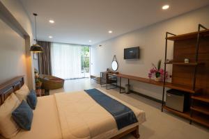 a bedroom with a large bed and a television at Alice Villa Hotel in Takeo