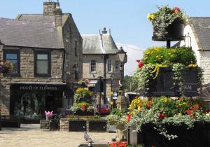 a street in a town with flowers and buildings at Woodworth Cottage in Barnoldswick