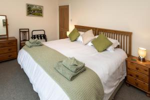 1 dormitorio con 2 camas y toallas verdes. en CRAVEN VUE - SKIPTON, en Skipton
