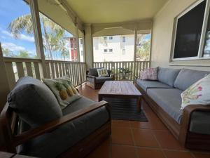 uma sala de estar com um sofá e uma mesa em Tiki Dreams - With A Large Breezy Balcony em Westcourt