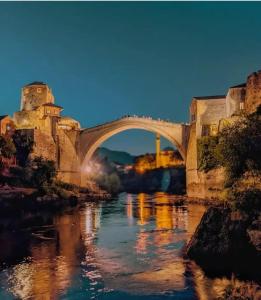 a bridge over a river with people walking on it at Hostel FM in Mostar