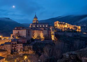 un bâtiment sur une colline avec une tour la nuit dans l'établissement Los Palacios, à Albarracín