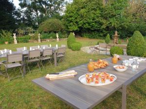 a picnic table with food on it in a yard at La Villa des Arts in Savigné-lʼÉvêque