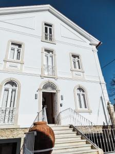 ein weißes Gebäude mit einer Treppe davor in der Unterkunft Casa de São Bento St Benedict House in Coimbra