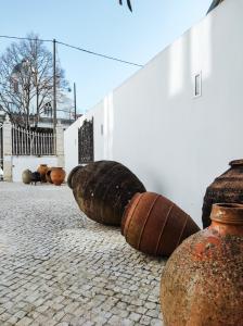 a group of wine barrels sitting next to a wall at Casa de São Bento St Benedict House in Coimbra