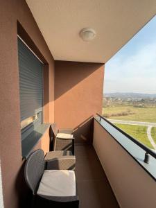 a balcony with chairs and a window with a view at Apartman Royal 4 in Doboj