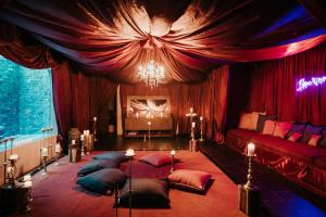 een slaapkamer met rode gordijnen en een bed met kussens bij Kings Mansion for 26 guests! in Tulum