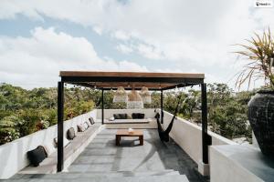 an outdoor patio with a couch and a table at Kings Mansion for 26 guests! in Tulum