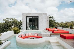 a swimming pool with red chairs and a swimming poolvisor at Kings Mansion for 26 guests! in Tulum