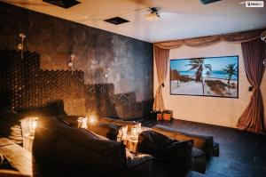 a living room with couches and a palm tree mural at Kings Mansion for 26 guests! in Tulum