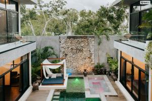 an outdoor patio with a chair and a rock wall at Kings Mansion for 26 guests! in Tulum