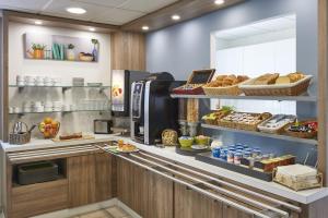 a kitchen with a counter with bread and a refrigerator at Atena Bordeaux Sud Est Créon - Vélo Friendly in Créon