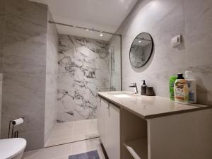 a white bathroom with a sink and a shower at BW Arcadia deluxe apartments in Sajmište +54 photos