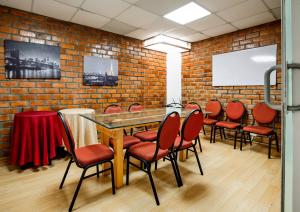 um quarto com uma mesa e cadeiras e uma parede de tijolos em El Centurión em Trujillo