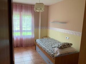 een kleine slaapkamer met een bed en een raam bij Finis Viae in Fisterra