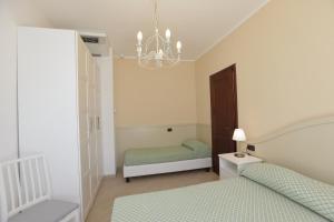 a bedroom with two beds and a chandelier at Residence Hotel Kriss in Deiva Marina