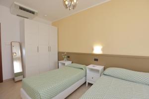 a bedroom with two beds and a mirror at Residence Hotel Kriss in Deiva Marina