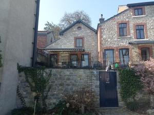 a stone house with a gate and a fence at Le Vieux Tribunal in Durbuy