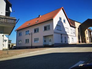 a white building with a red roof on a street at Ferienwohnung Gebauer in Hornbach