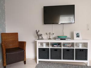 a white entertainment center with a television on a wall at Ferienwohnung Gebauer in Hornbach