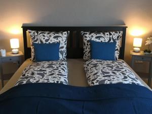 a bedroom with a bed with blue and white pillows at Ferienwohnung Gebauer in Hornbach