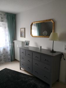 Dormitorio con tocador con espejo y lámpara en Ferienwohnung Gebauer, en Hornbach