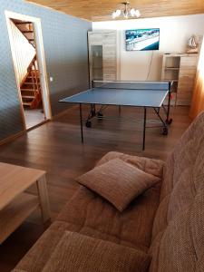 a ping pong table in a living room with a couch at Holiday Country House in Mārkalne