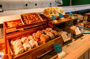 a bakery with different types of bread and pastries at Hilton Garden Inn Rebouças in Sao Paulo