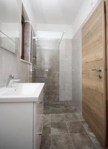 a bathroom with a sink and a shower with a door at Villa Seaside in Krk