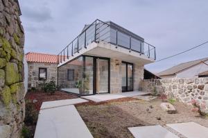 una casa con techo de cristal y pared de piedra en Casa Espelho D'Água, en Vouzela