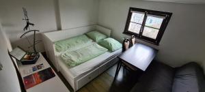 Habitación pequeña con cama y ventana en Private room in our home with free VVO ticket & cats, en Pirna
